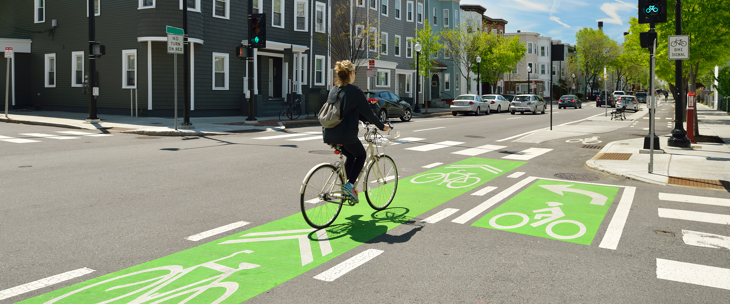 person riding a bike in a bike lane with bright green paint